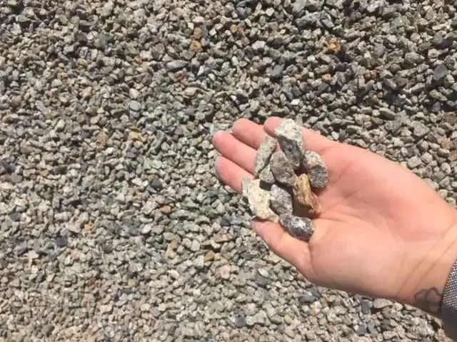 A Person Is Holding A Pile Of Gravel In Their Hand — Twin Towns Sand & Gravel In Tweed Heads South, NSW