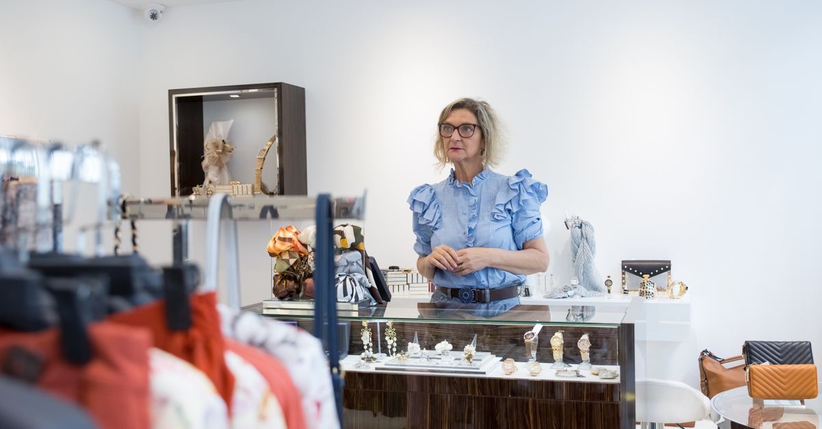 Commerçant photographiant la façade de sa boutique avec un smartphone