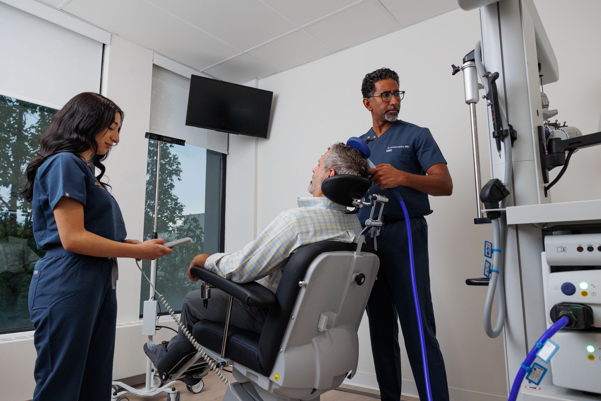 Two clinicians assist a patient in a dental exam chair in a modern clinic.