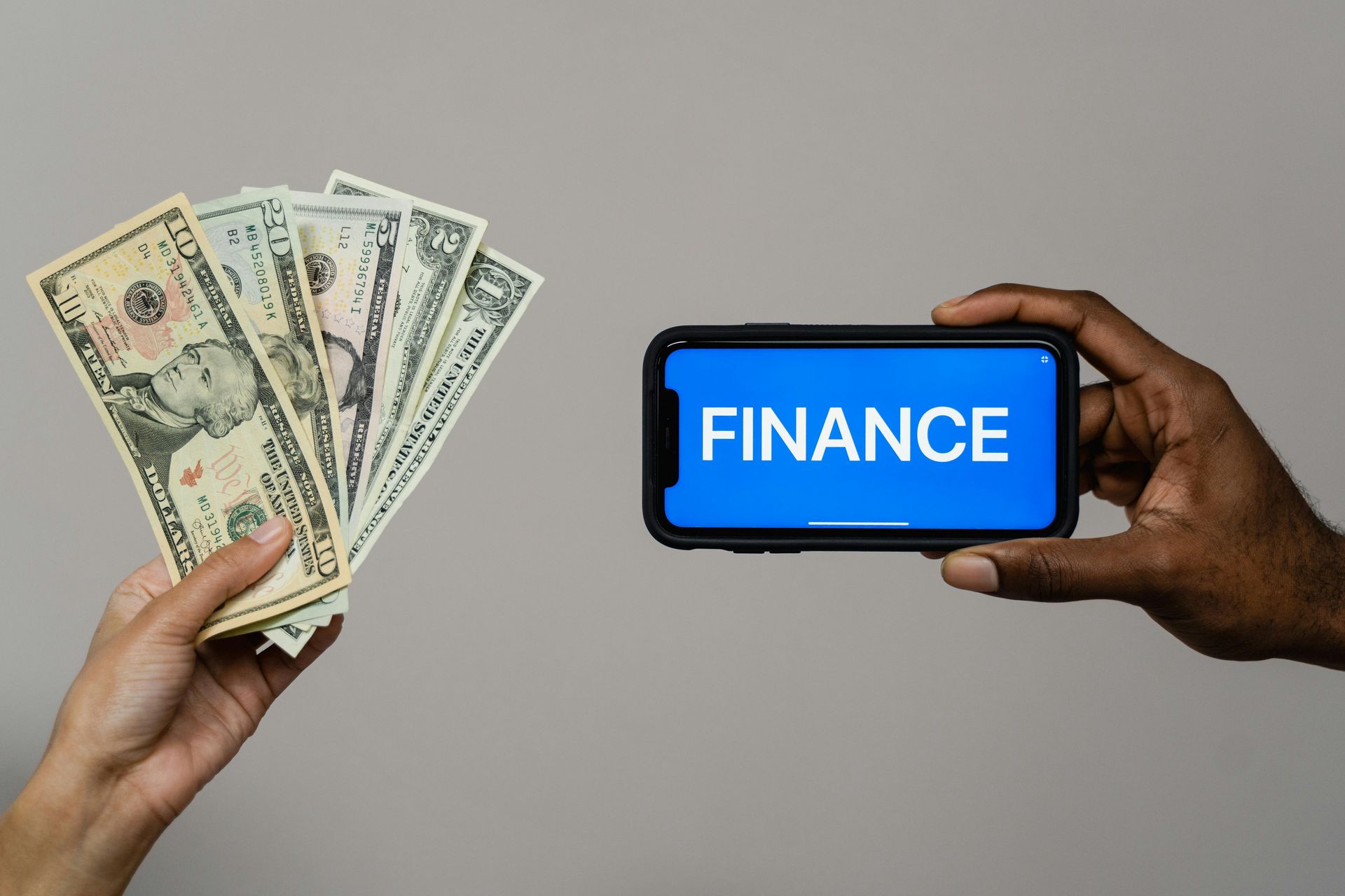 Hands holding money and a phone screen displaying 