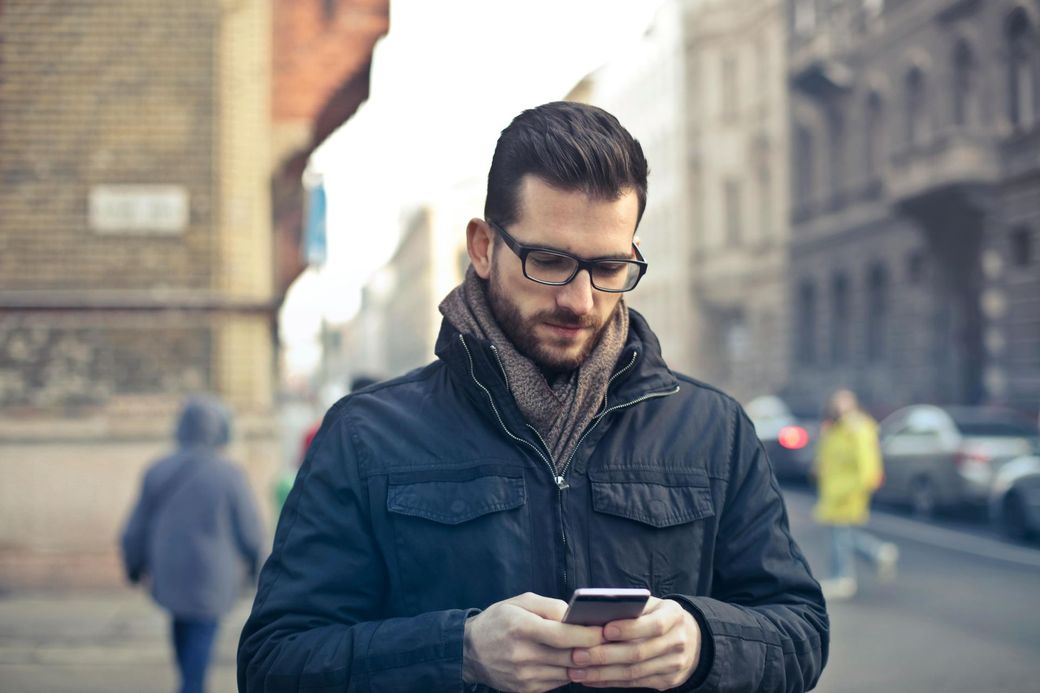 Man checks his a phone before a telehealth
counseling appointment.