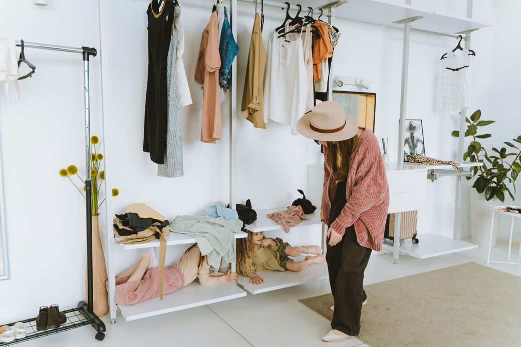 Woman leans down to talk with a child who is hiding in the closet.