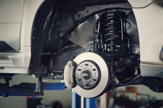 A Car is Sitting on a Lift in a Garage — High Grade Tyre and Mechanical in Toowoomba City, QLD
