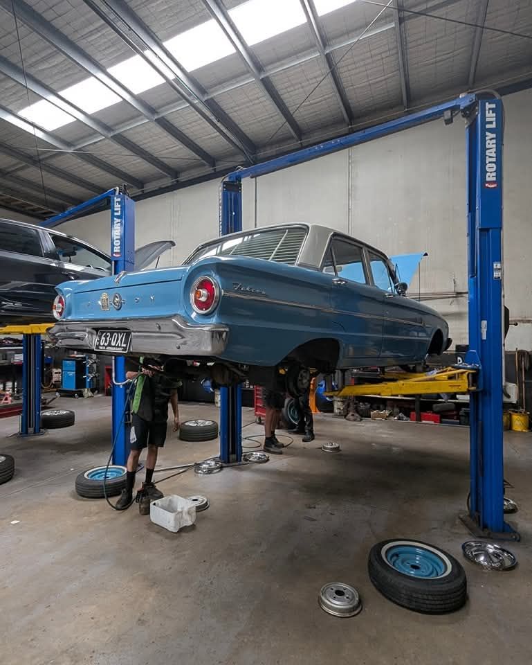 A Blue Car on a Lift in a Garage Brake Services — High Grade Tyre and Mechanical in Toowoomba City, QLD