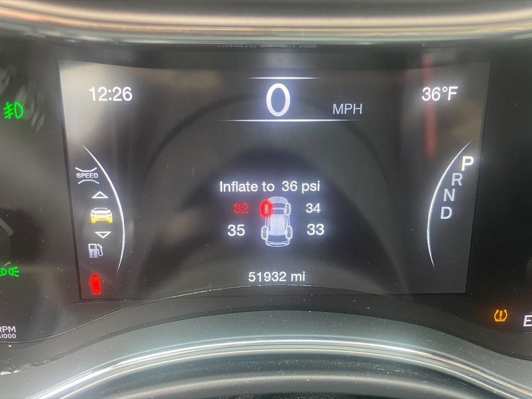 Dashboard displaying tire pressure warning, tire PSI readings, and