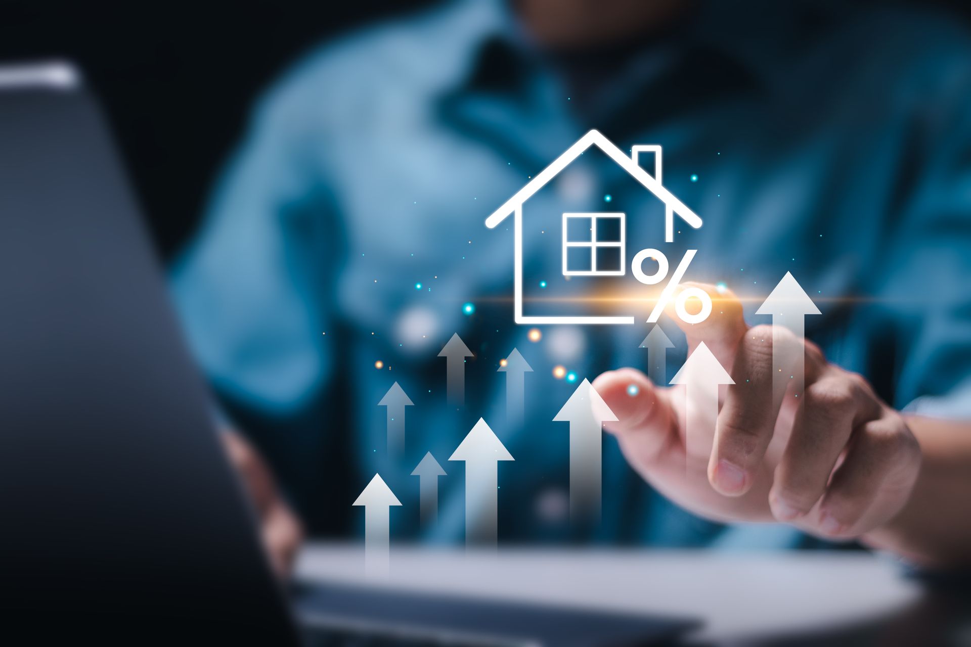 Person using laptop, touching a house icon with rising arrow graphics, symbolizing interest rate increases.