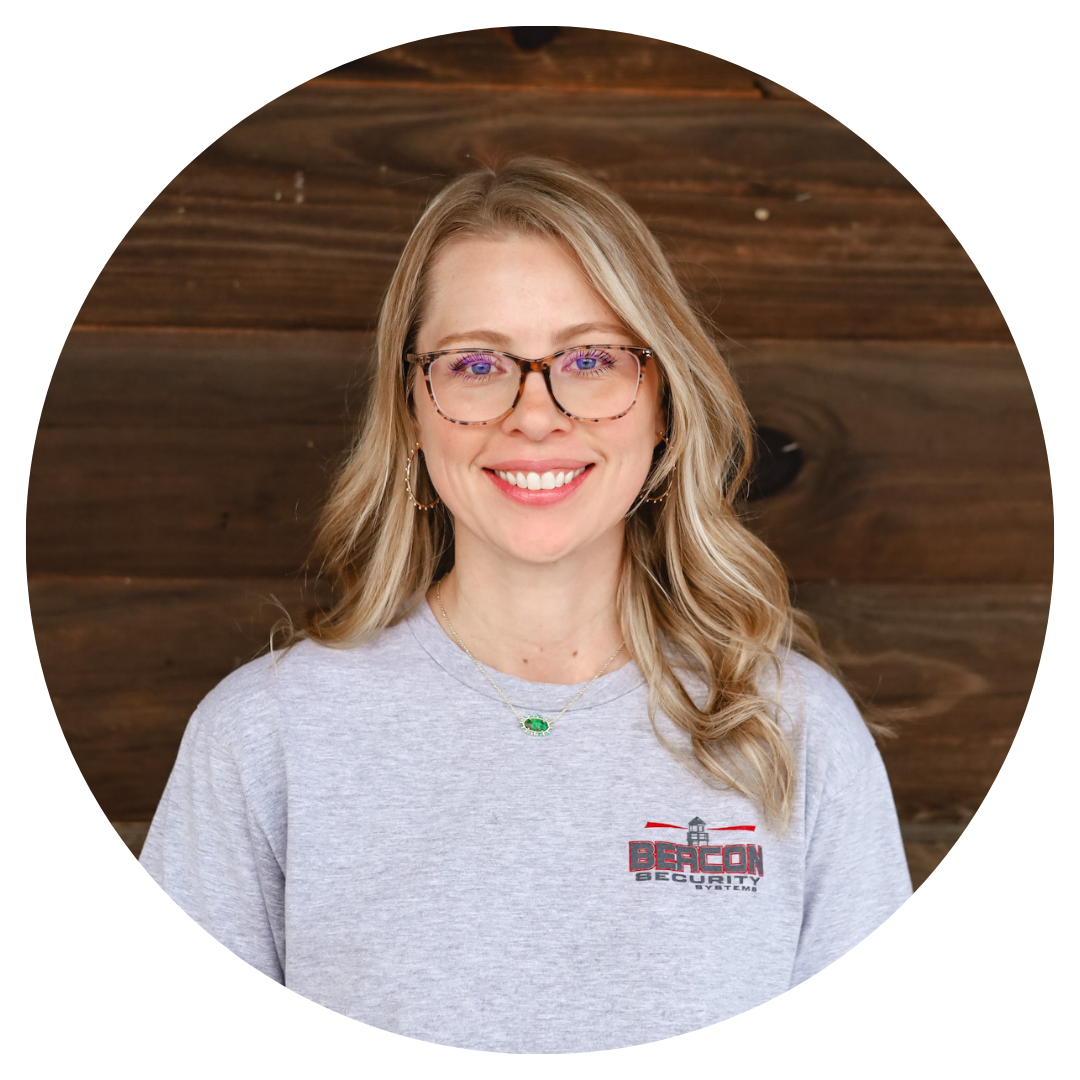 A woman wearing glasses and a grey shirt with the word bacon on it