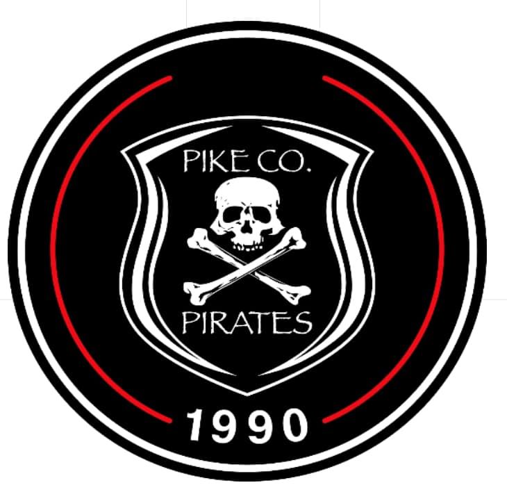 Pike Co. Pirates circular black logo with skull and crossed bones, red ring, and “1990” text