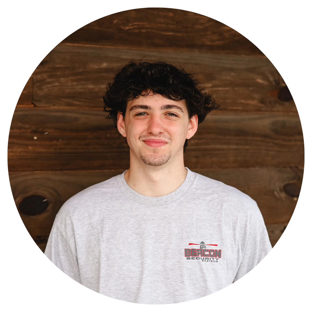 A young man wearing a grey shirt with a logo on it