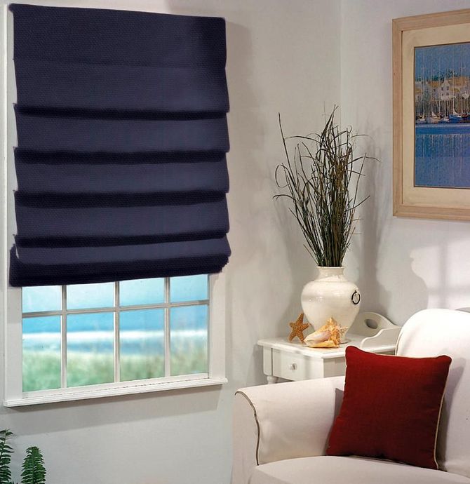 Cozy living room with navy Roman shade, white chair with red pillow, side table, and floral vase