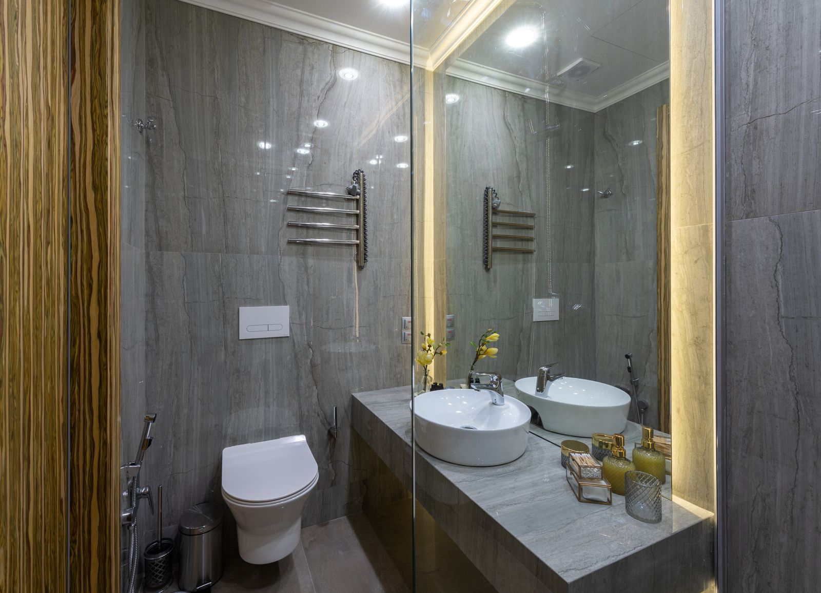 A bathroom with two sinks , a toilet , and a large mirror.