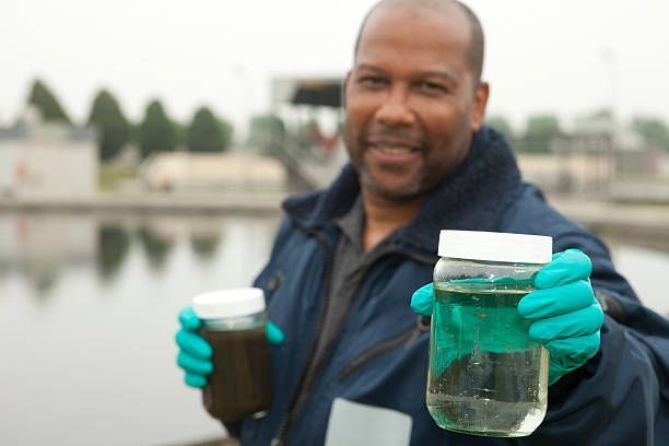 A man wearing a blue jacket displays two jars of water, emphasizing water treatment methods.