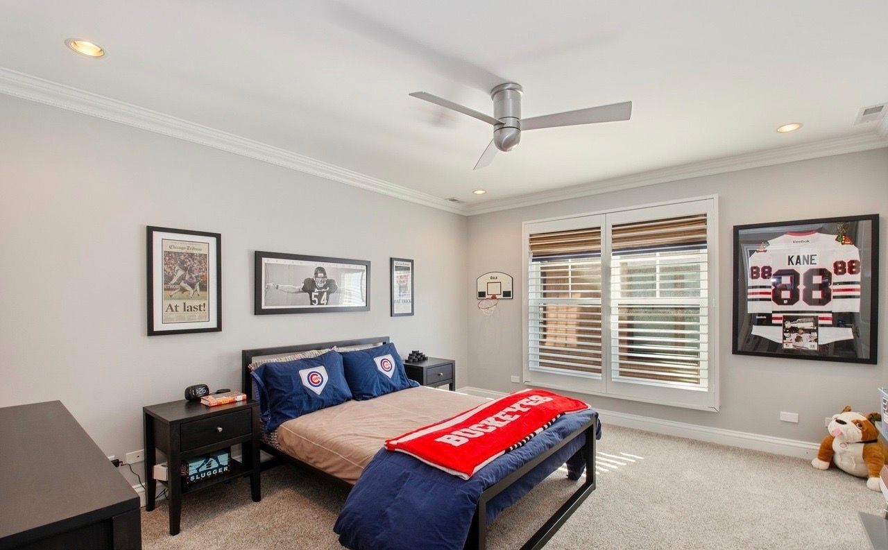 A bedroom with a bed and a ceiling fan.