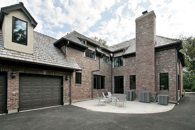 A large brick house with two garages and a patio