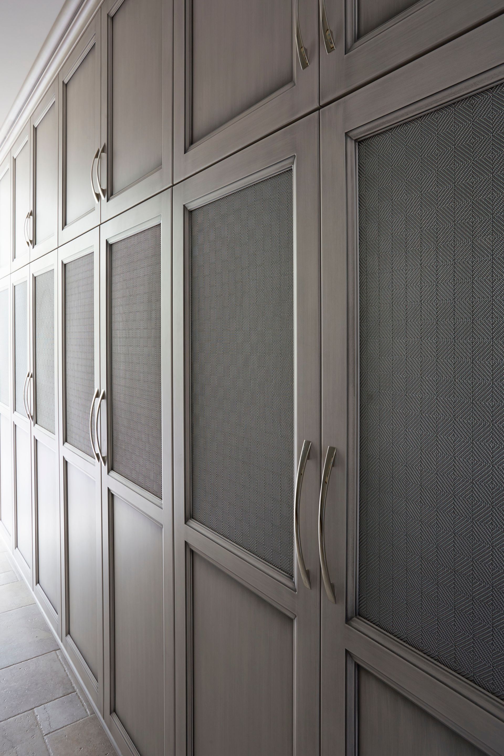 A hallway with a lot of cabinets and glass doors.