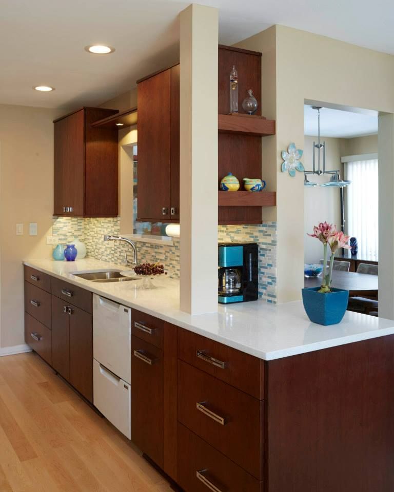 A kitchen with wooden cabinets and white counter tops