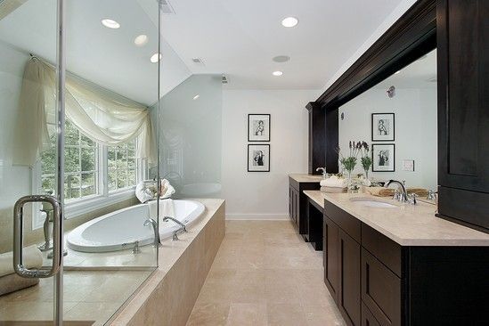 A bathroom with two sinks , a tub and a walk in shower.