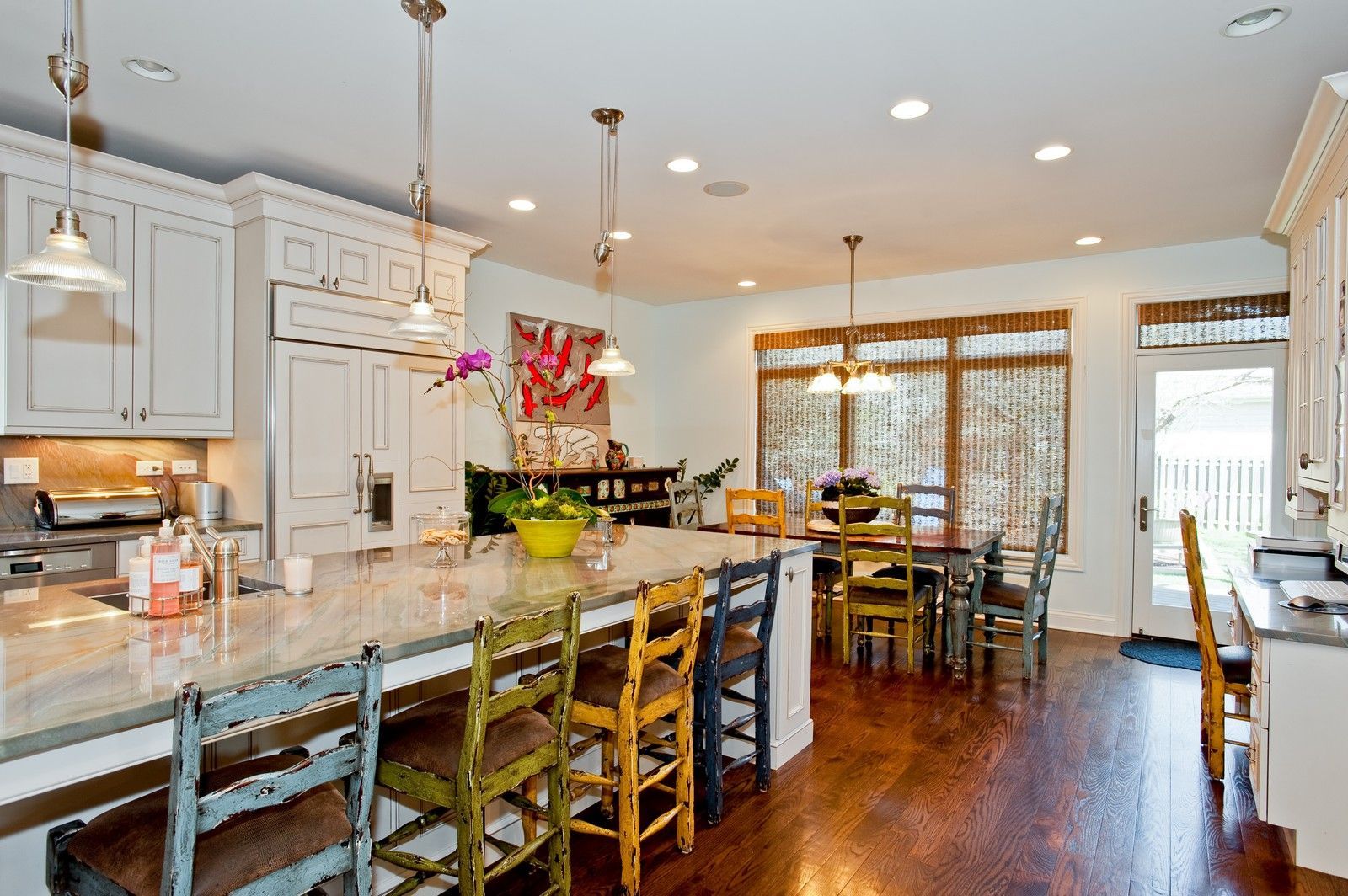 A kitchen with a large island and lots of chairs