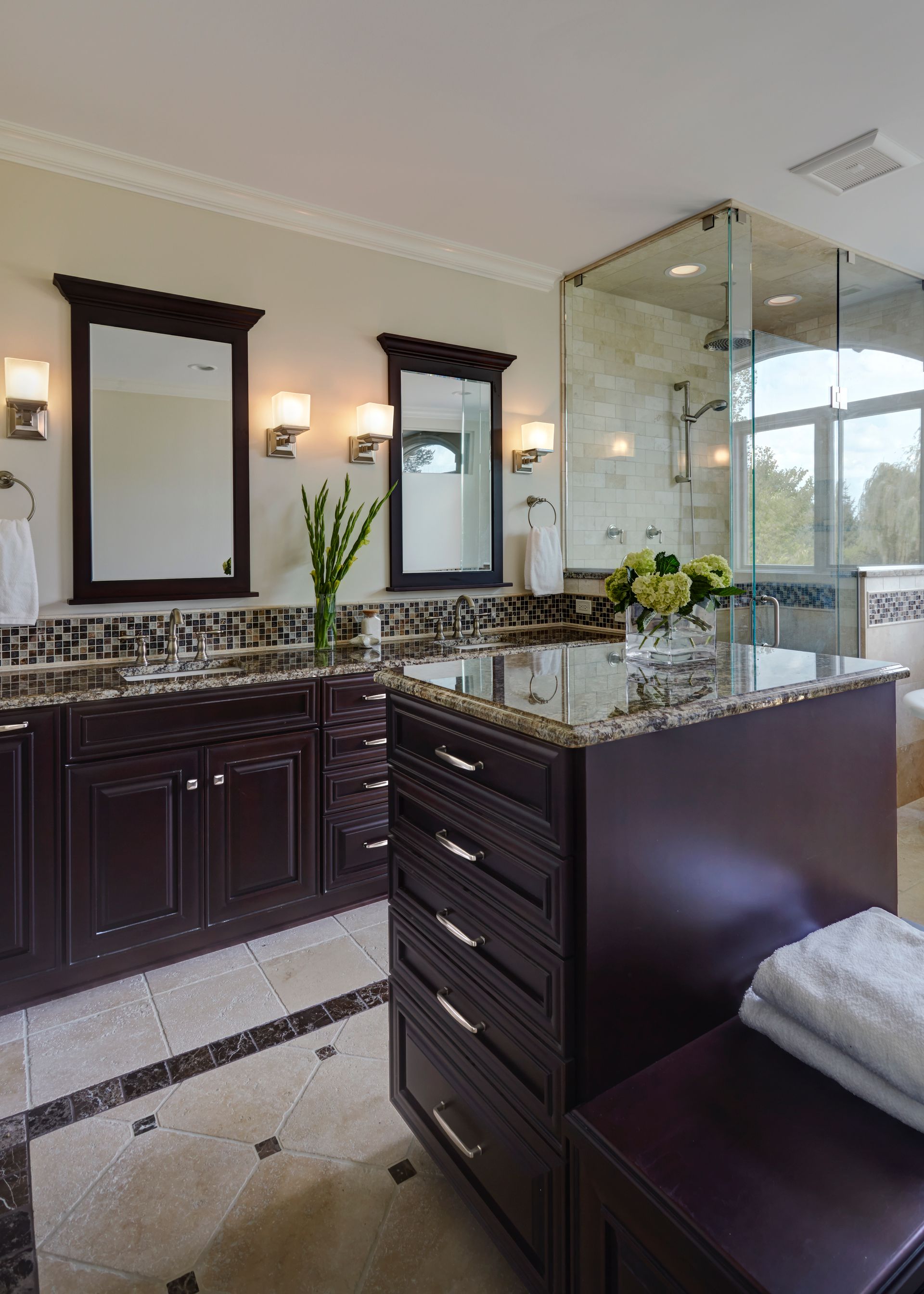 A bathroom with two sinks and a walk in shower