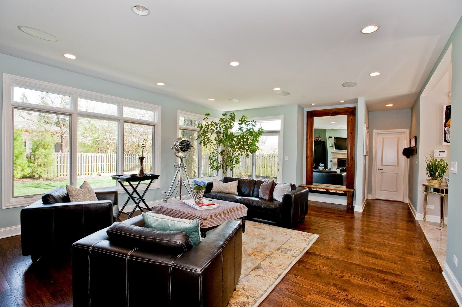A living room filled with furniture and a large mirror.
