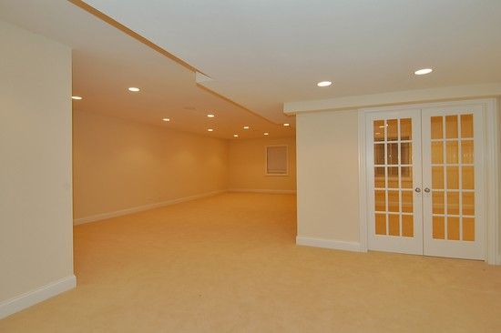 An empty room with white walls and french doors