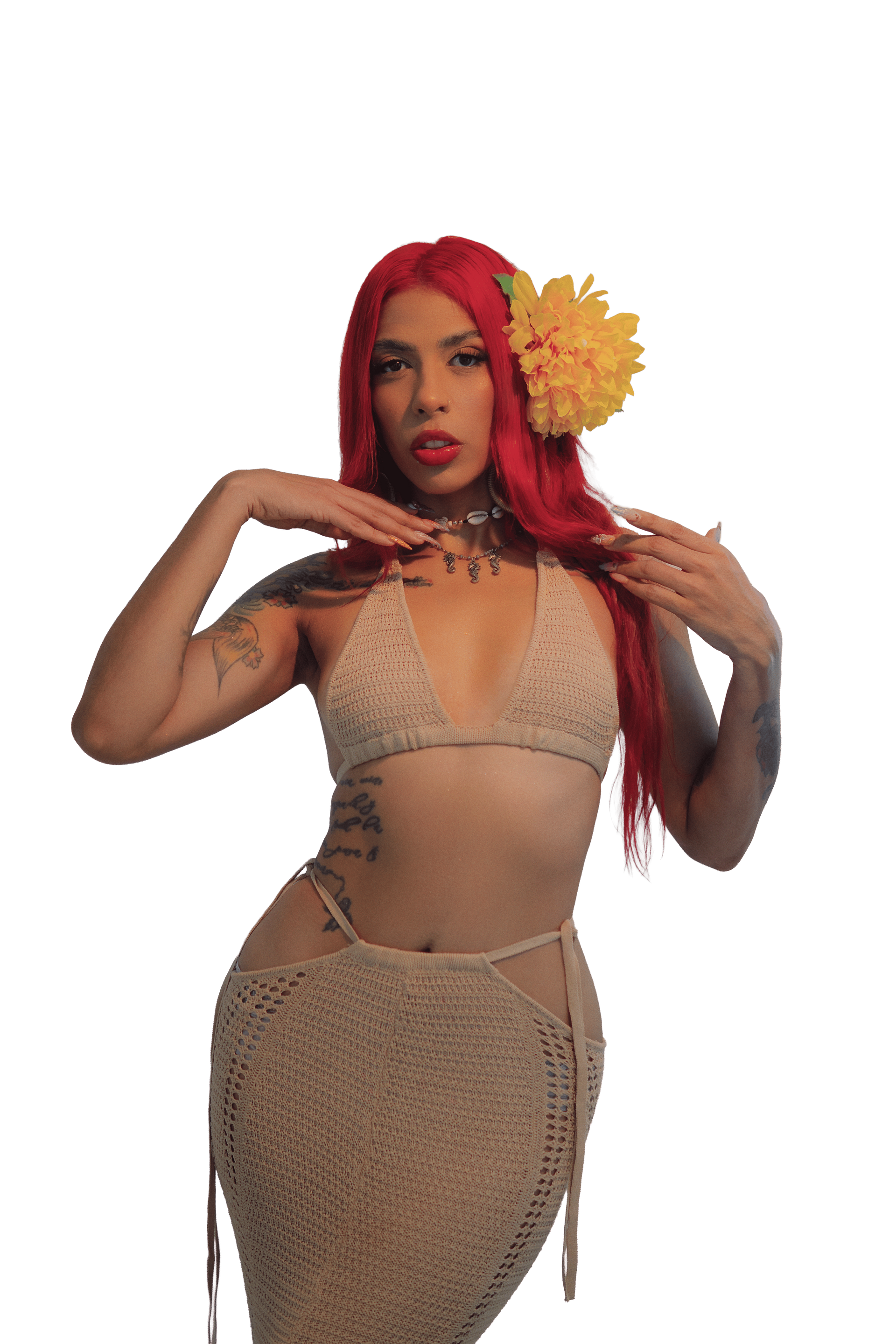 Mujer posando con un conjunto de ganchillo color beige y una gran flor amarilla en su cabello rojo.