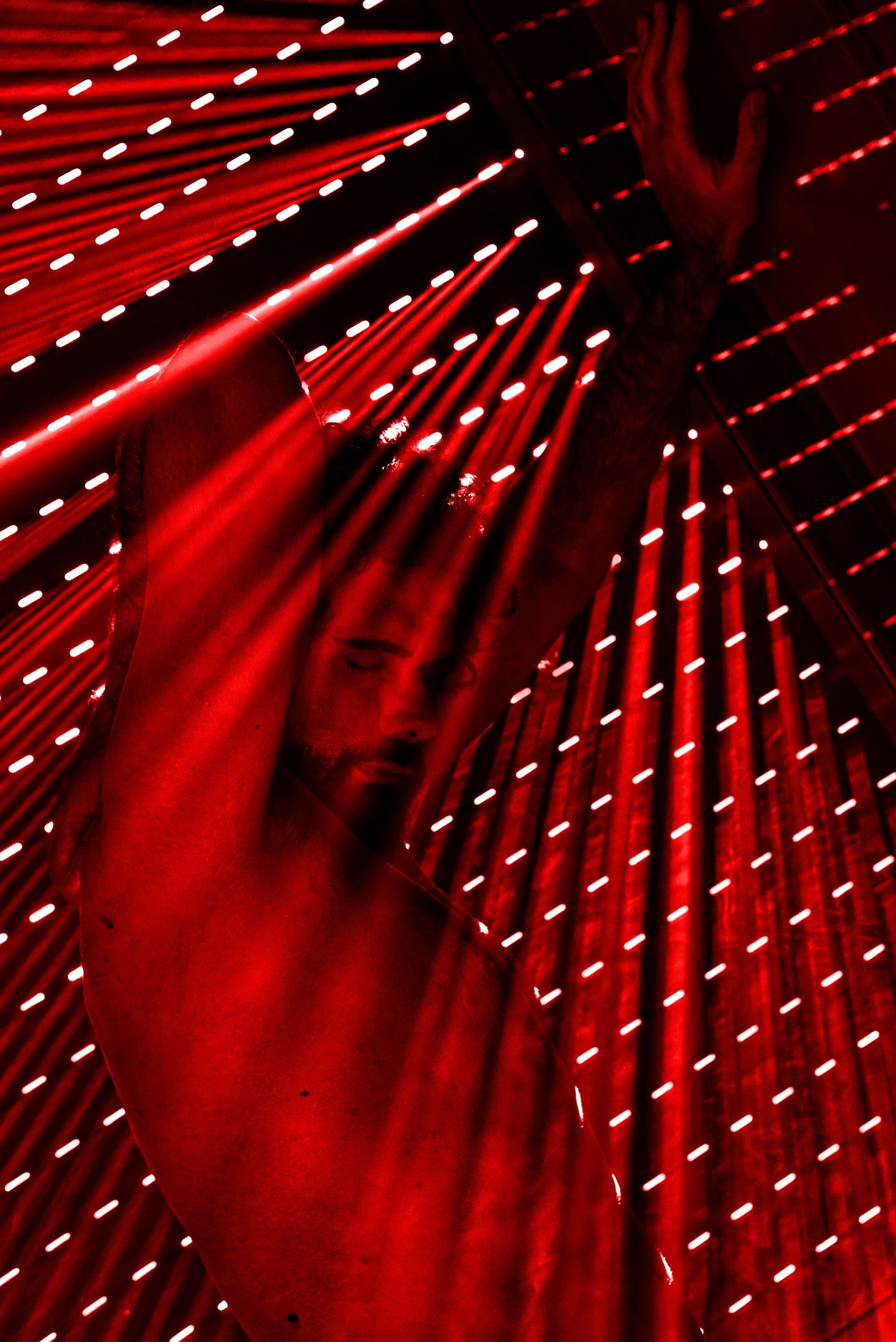 Red abstract light installation with glowing beams radiating across a dark background
