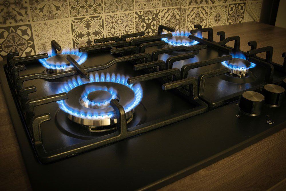 A Close Up of a Gas Stove With Flames Coming Out of It — Greg Mitchell Plumbing In Murgon, QLD