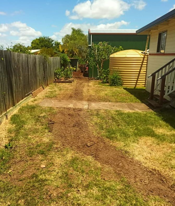 A House With a Yellow Water Tank in the Backyard — Greg Mitchell Plumbing In Wondai, QLD