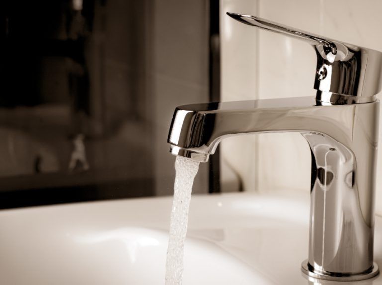 A Bathroom Sink With Water Running From a Chrome Faucet — Clinton McArthur Plumbing in Landsborough, QLD