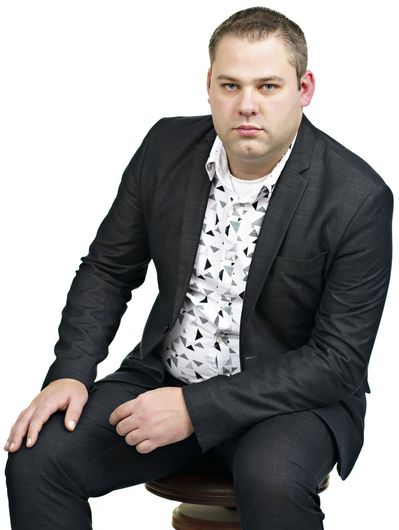 A man in a suit is sitting on a stool