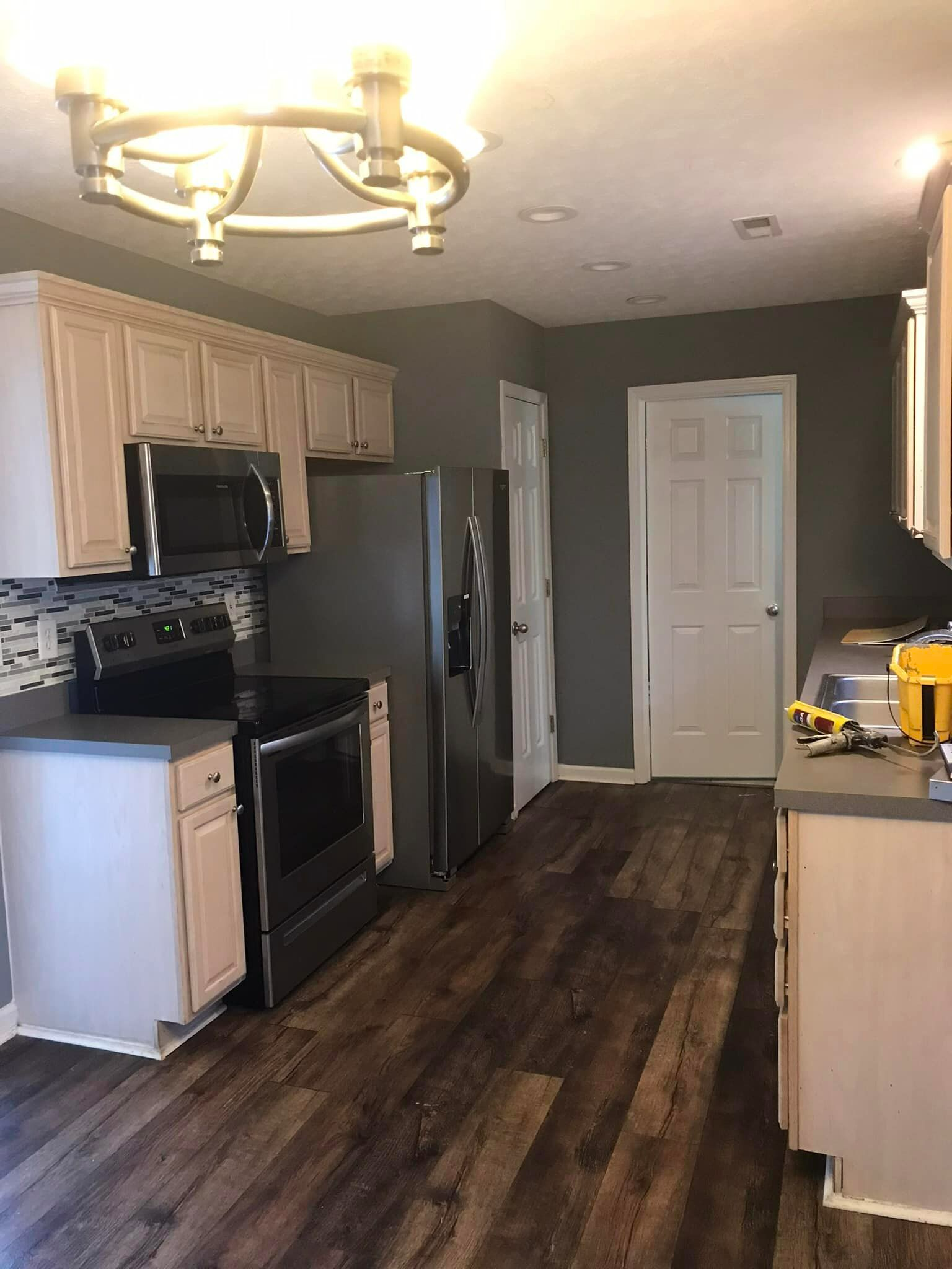 A kitchen with stainless steel appliances and wooden floors.