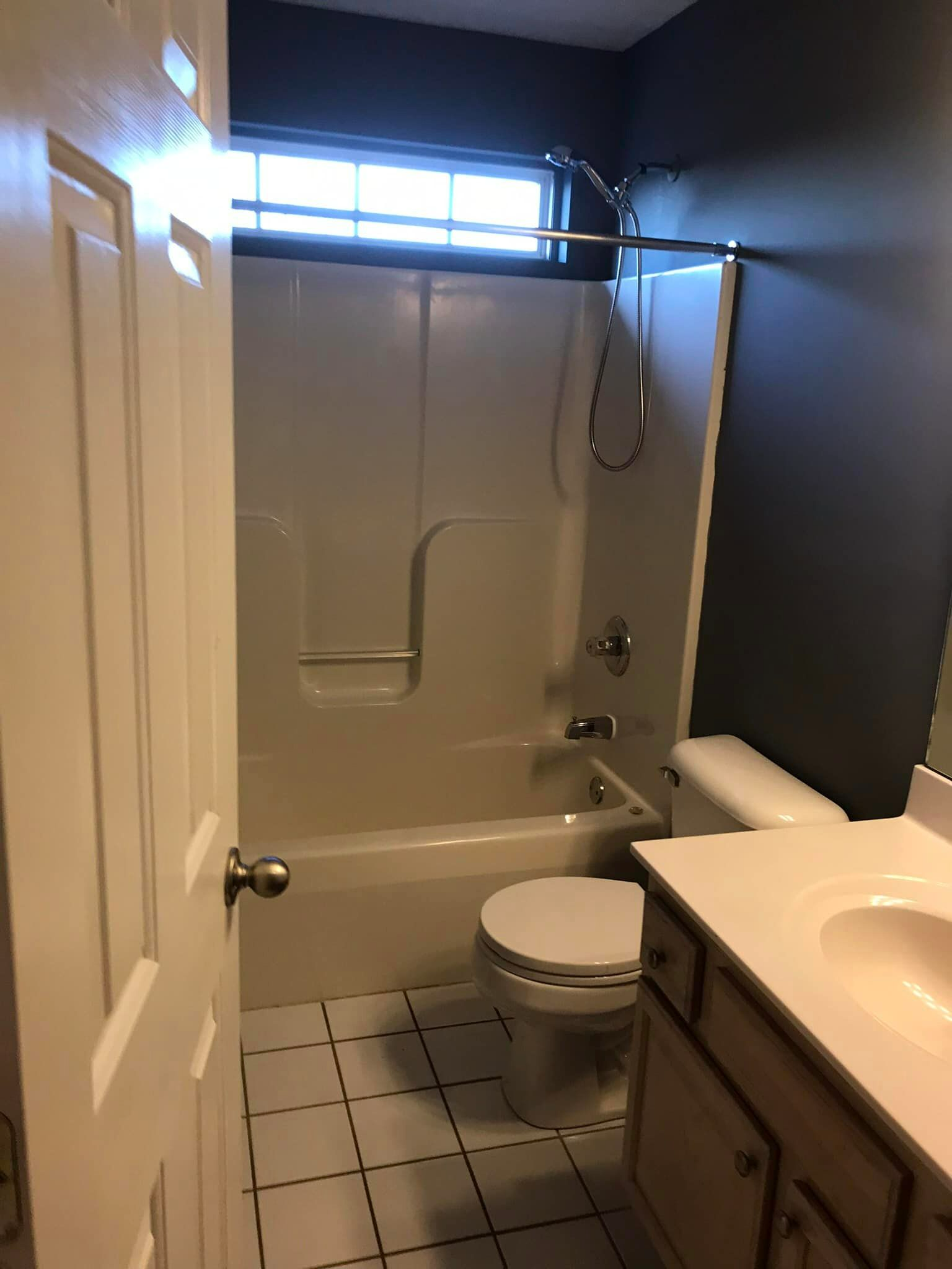 A bathroom with a tub , toilet , sink and shower.