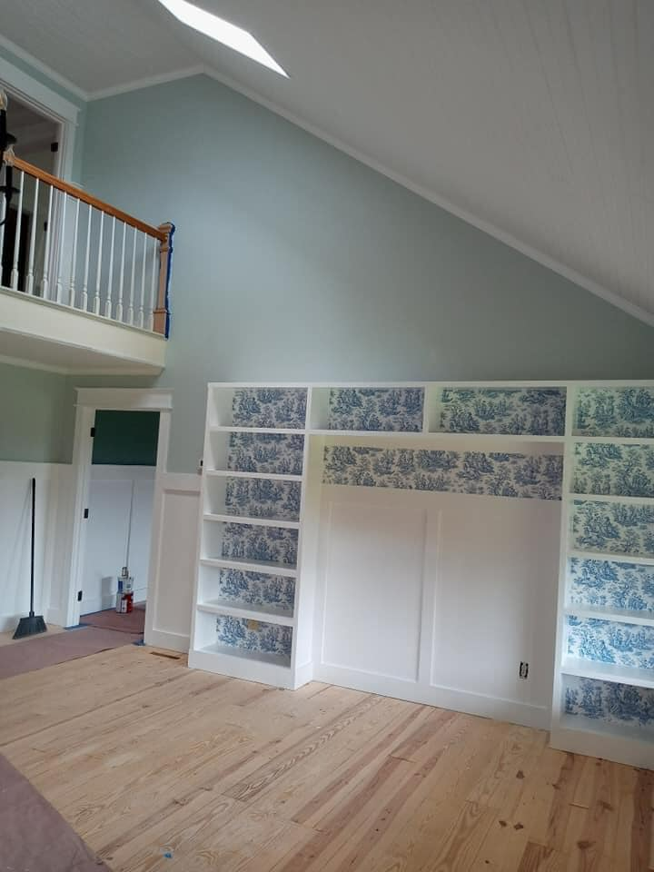 An empty room with a staircase and lots of shelves