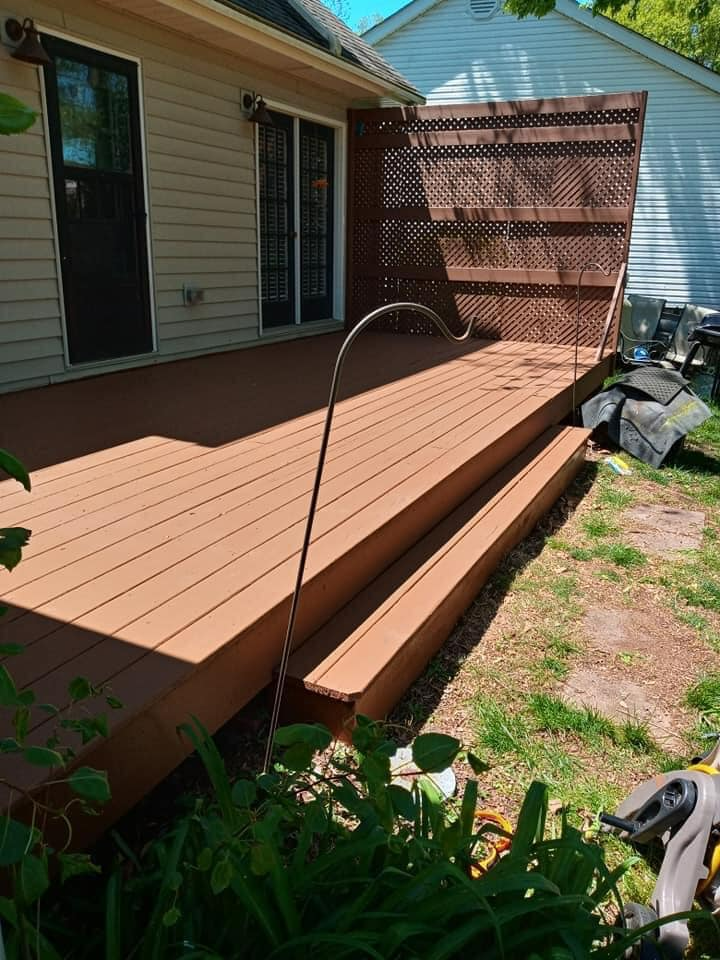 A wooden deck is sitting in front of a house.
