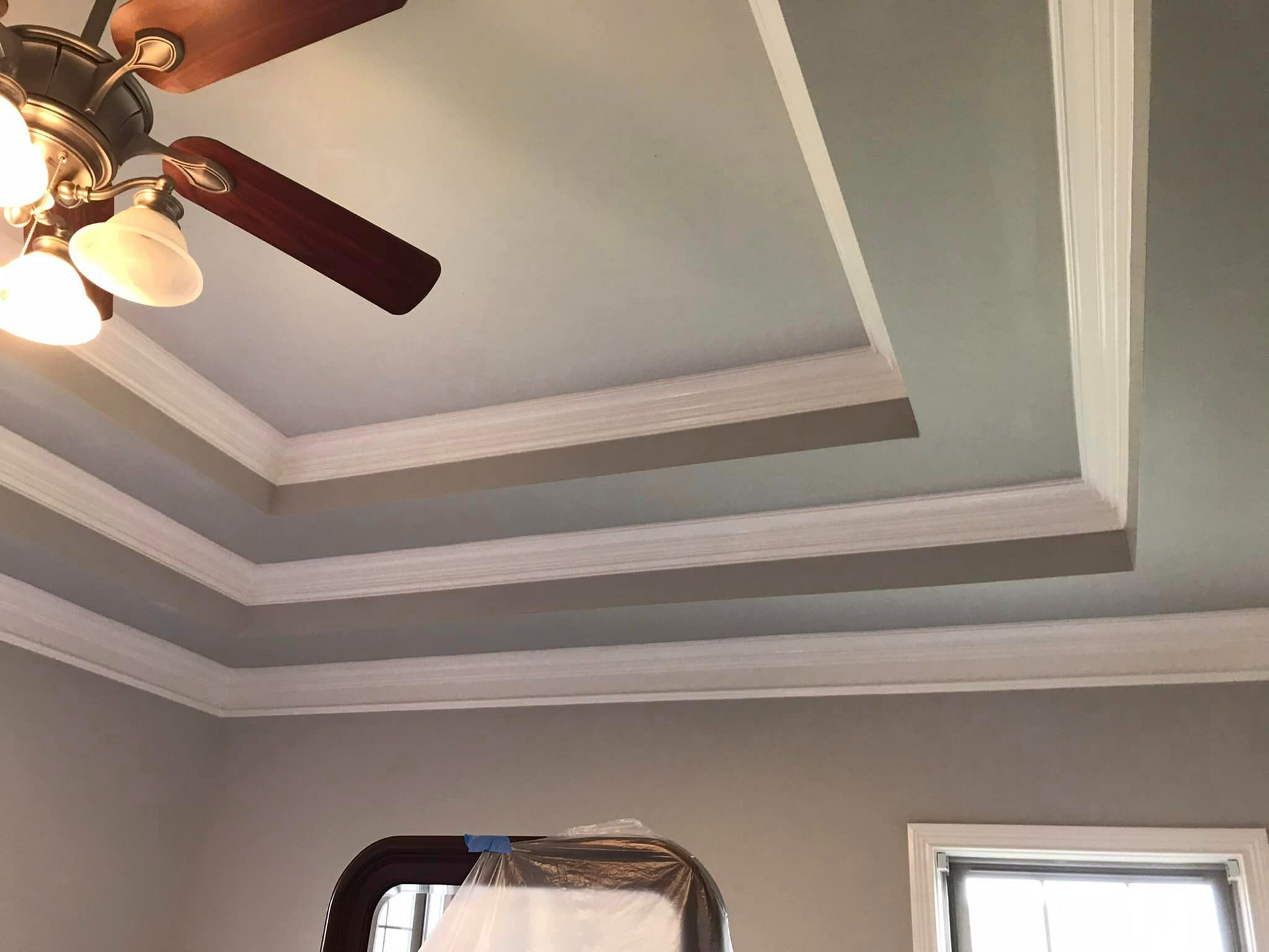 A ceiling fan is hanging from the ceiling of a room.