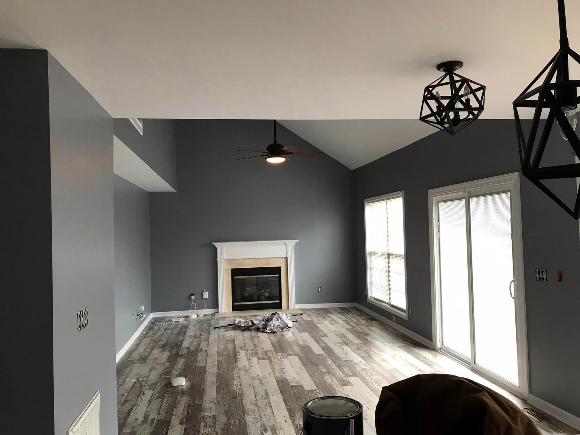 A living room with a fireplace and a ceiling fan.