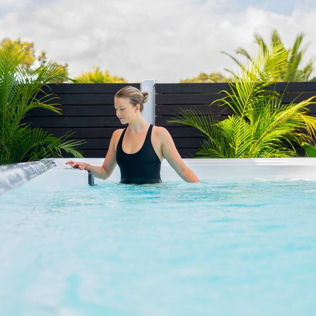 Woman in a Black Swimsuit Relaxing in a Bright Pool — Just Spas Forster in Forster, NSW