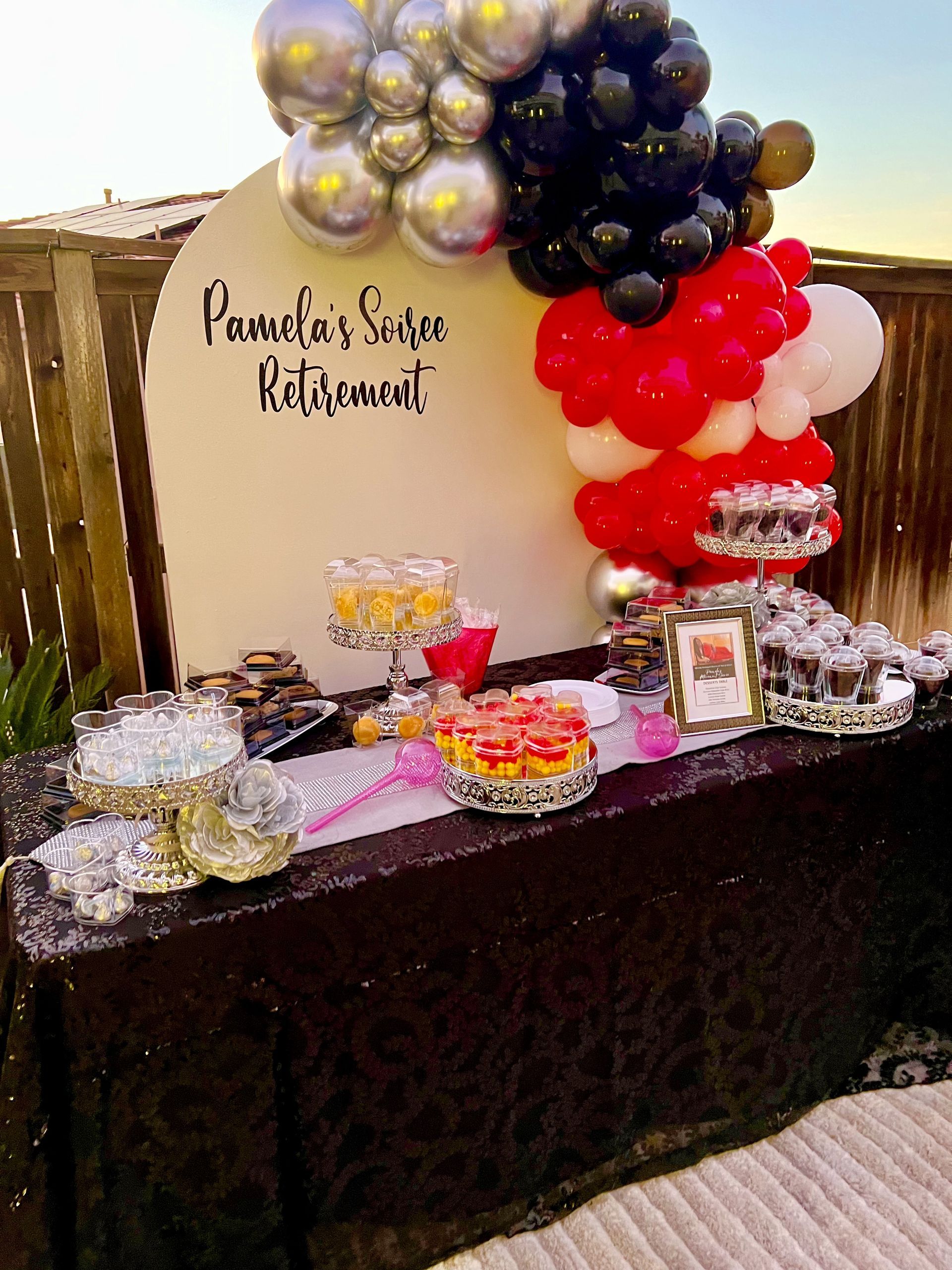 Retirement party table with balloons, food, and a sign that says
