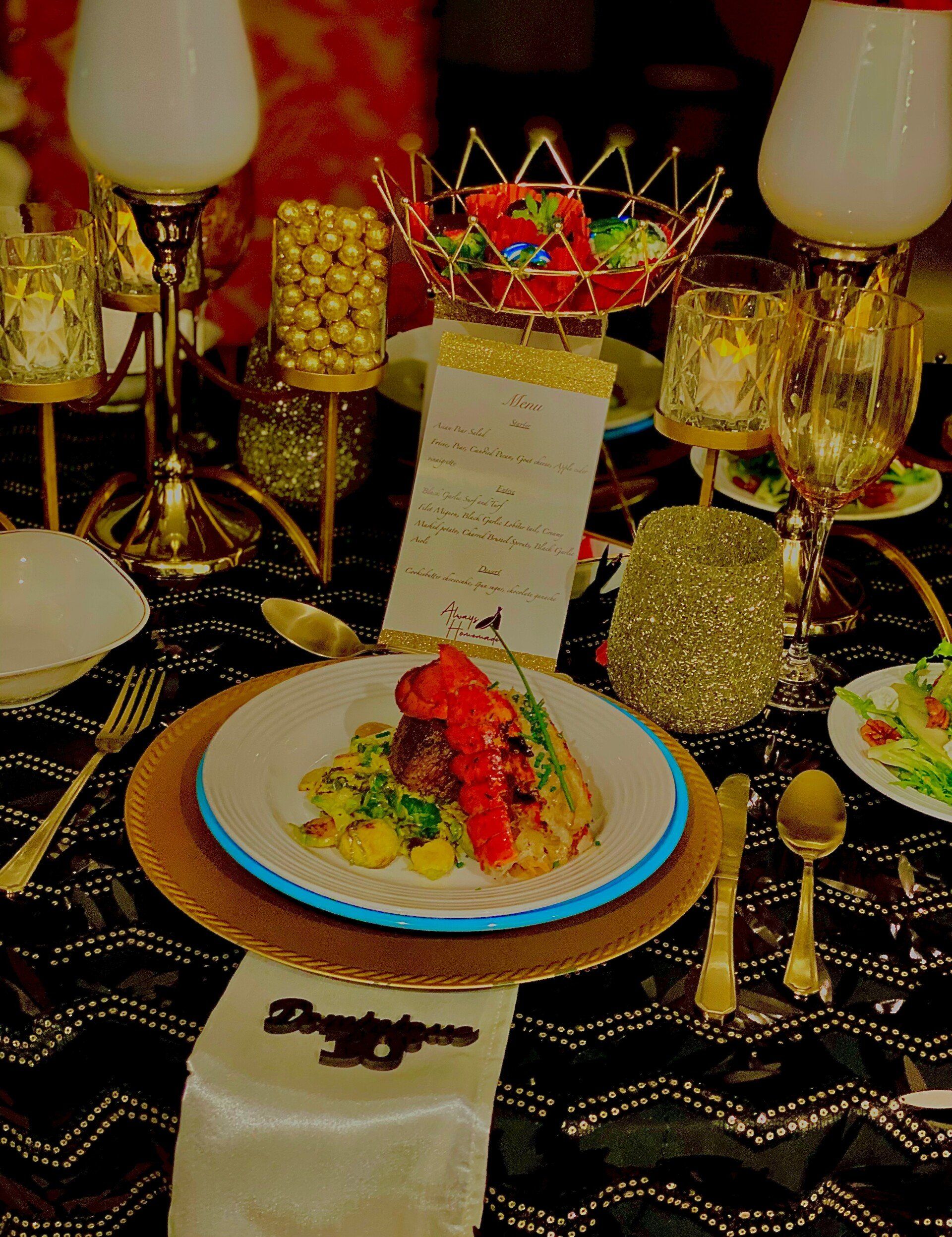 Elegant dinner table with gold decor, food, and menu.