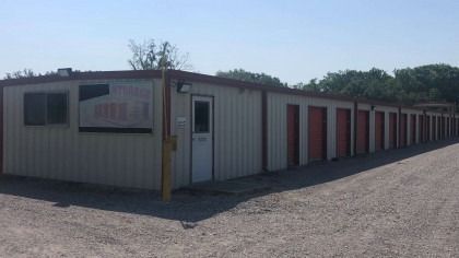 Storage facility with beige office and red storage unit doors.
