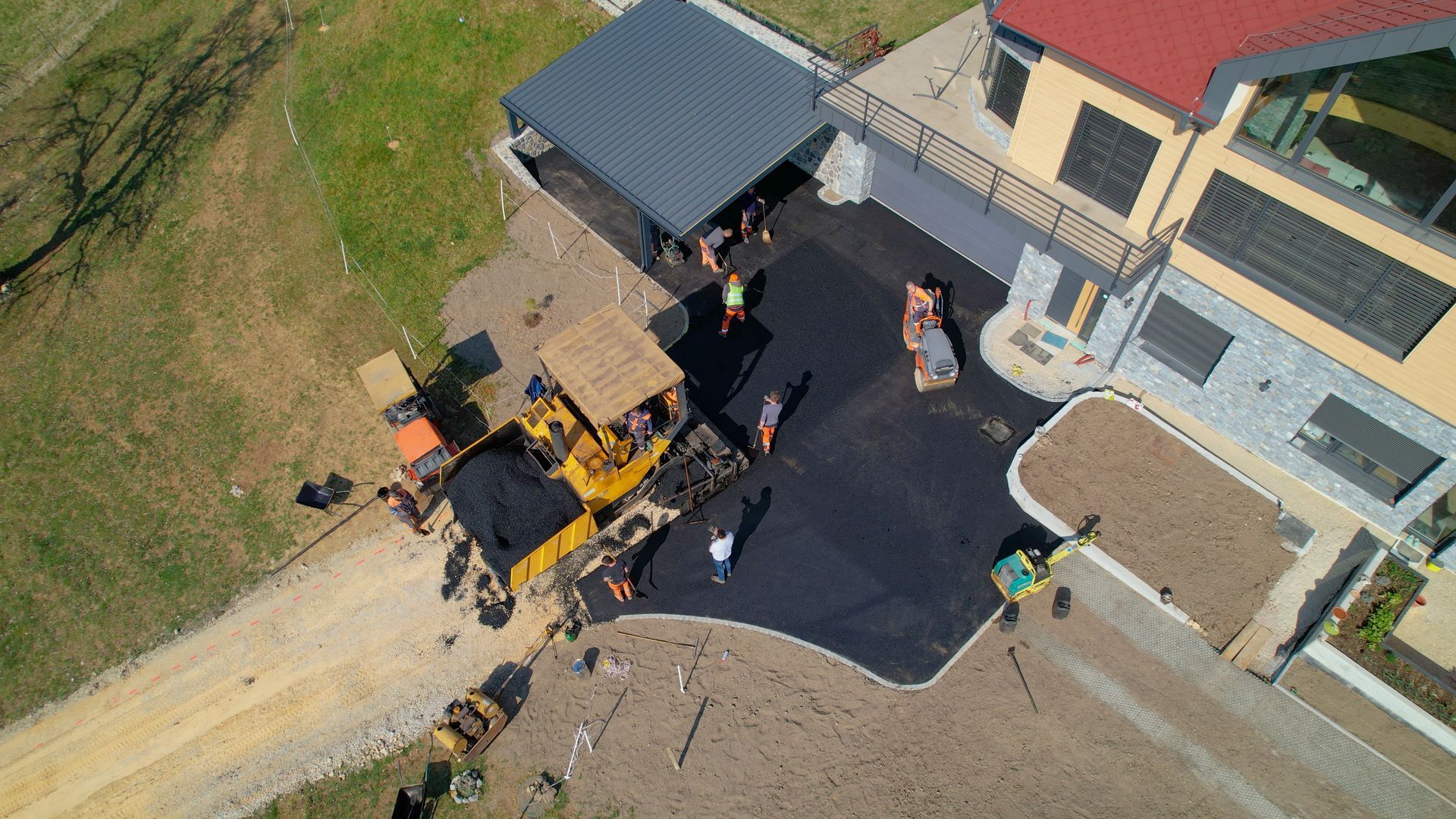 A group of workers are paving a driveway.