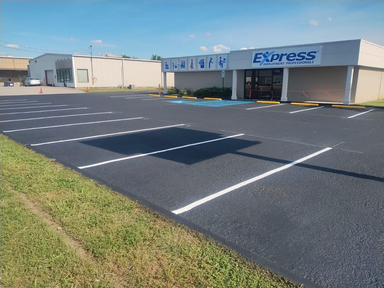 Newly paved parking lot in front of a building with the sign 