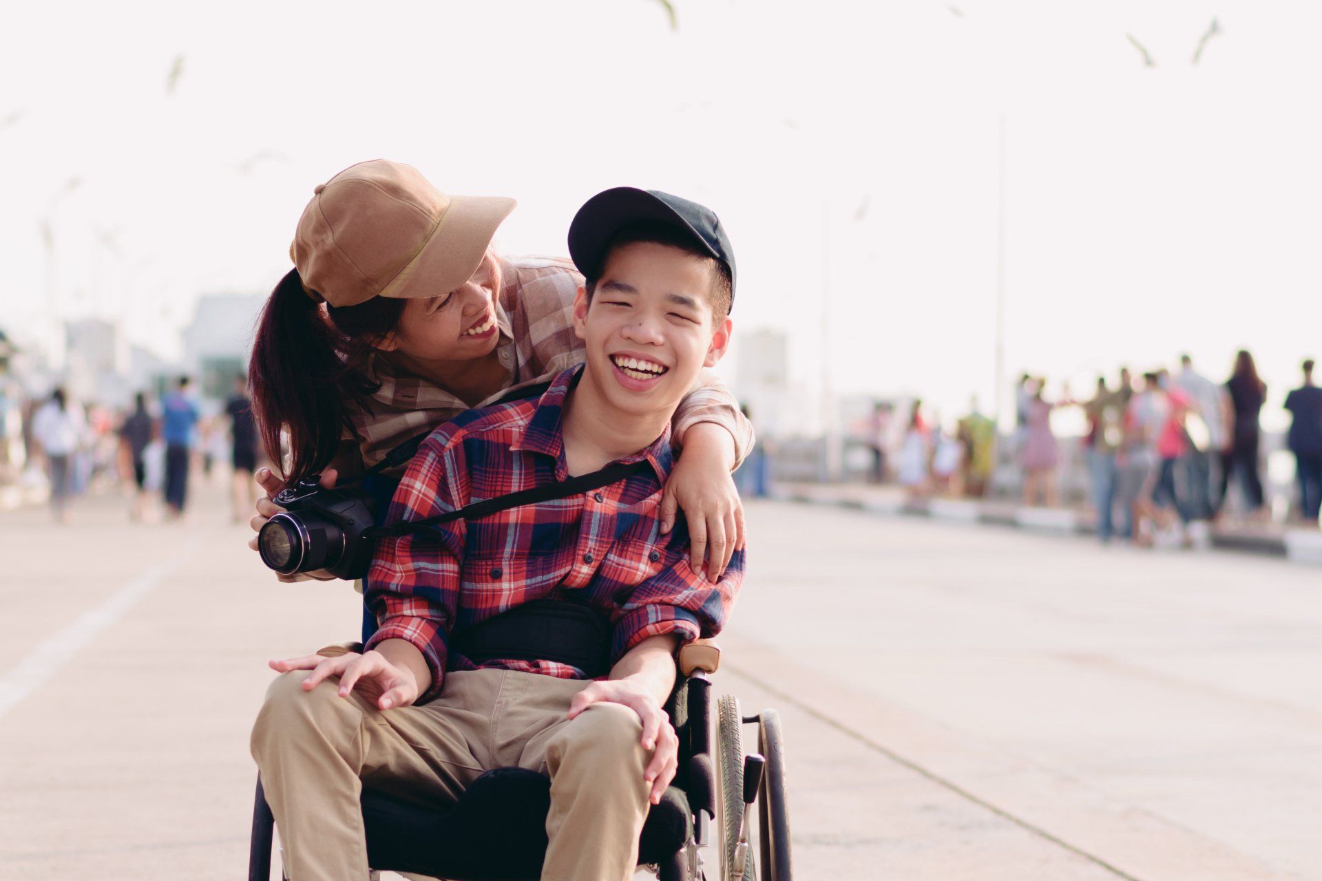 A woman is sitting on the back of a man in a wheelchair.