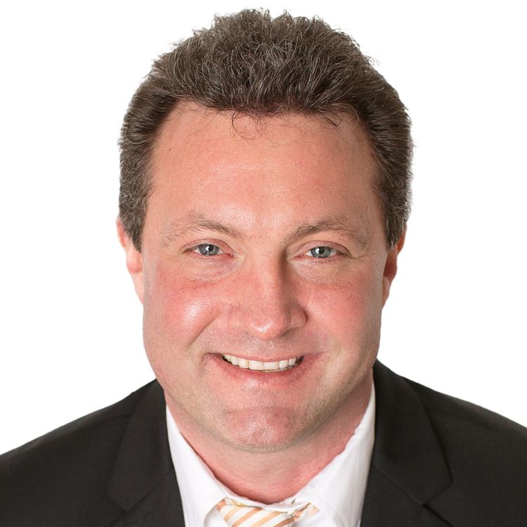 A man in a suit and tie smiles for the camera
