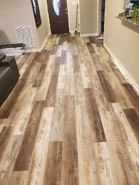 Wood-look flooring in a home entrance. Boards vary in shades of brown and tan.