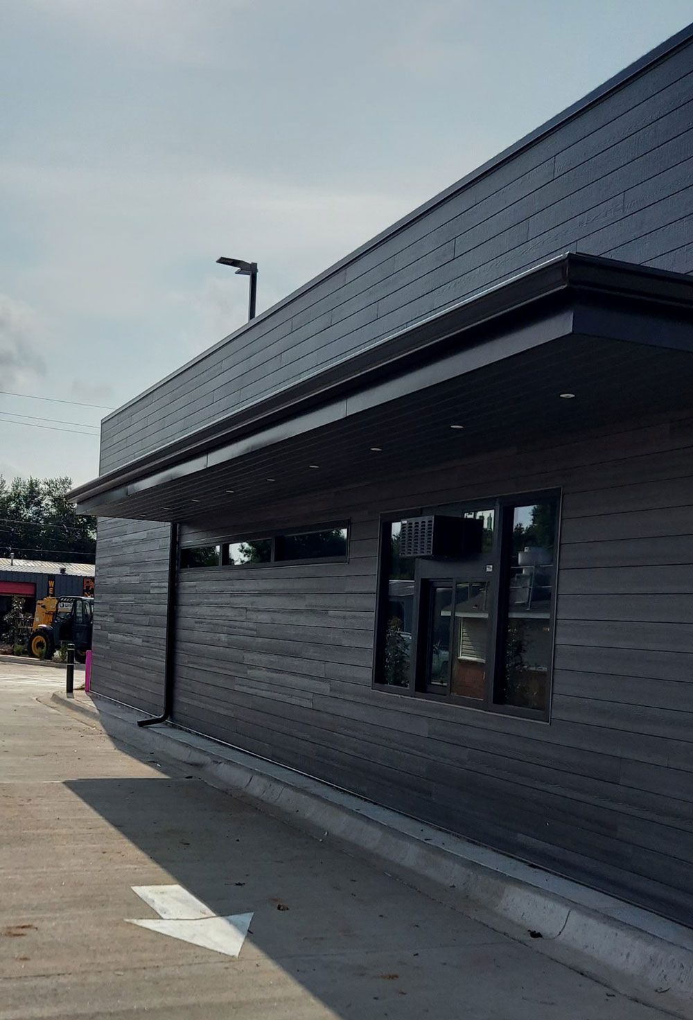 A black building with a lot of windows and a canopy.