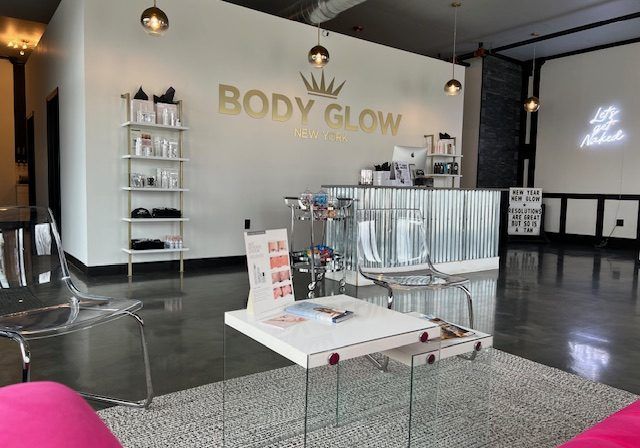 A room with a table and chairs and a sign that says body glow
