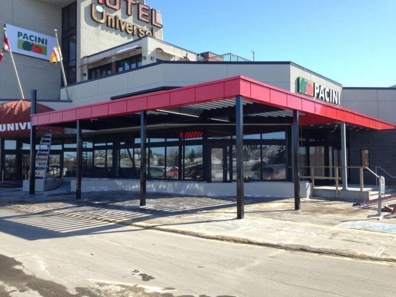 Le restaurant Pacini, avec son toit rouge et ses supports noirs, est relié à l'Hôtel Universel.