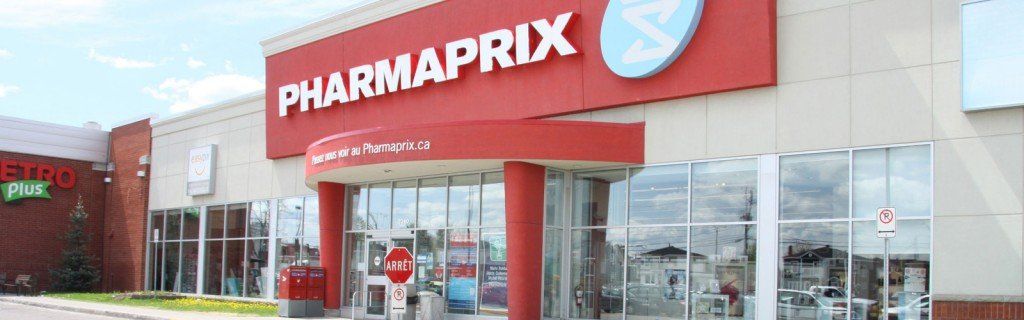 Extérieur d'une pharmacie Pharmaprix avec une façade rouge et blanche. L'entrée est dotée de portes vitrées et d'un auvent rouge.